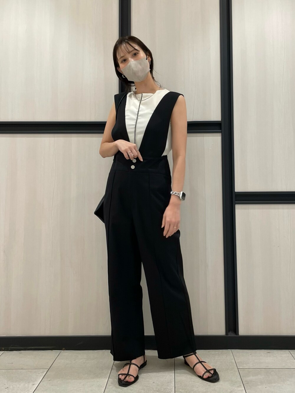 ブラック系のサンダル、ホワイト系のTシャツ/カットソー、ブラック系のサロペット/オーバーオールを着用したレディースの春コーディネートの2枚目の写真