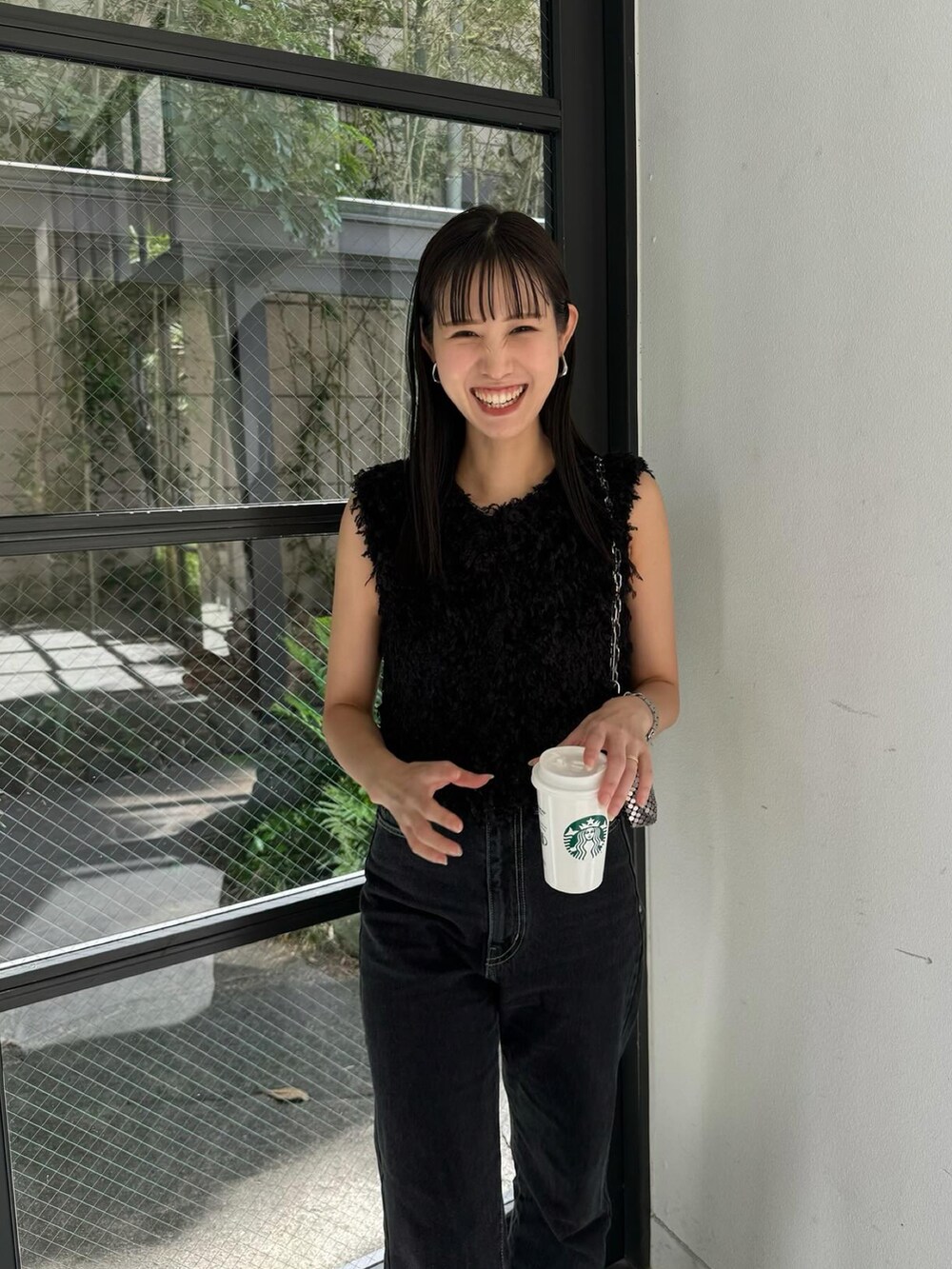 ブラック系のシャツ/ブラウス、ブラック系のデニムパンツ、シルバー系のサンダルを着用したレディースの夏コーディネートの2枚目の写真