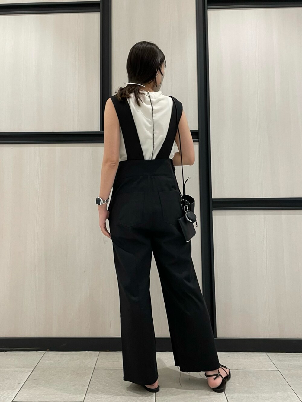 ブラック系のサンダル、ホワイト系のTシャツ/カットソー、ブラック系のサロペット/オーバーオールを着用したレディースの春コーディネートの4枚目の写真