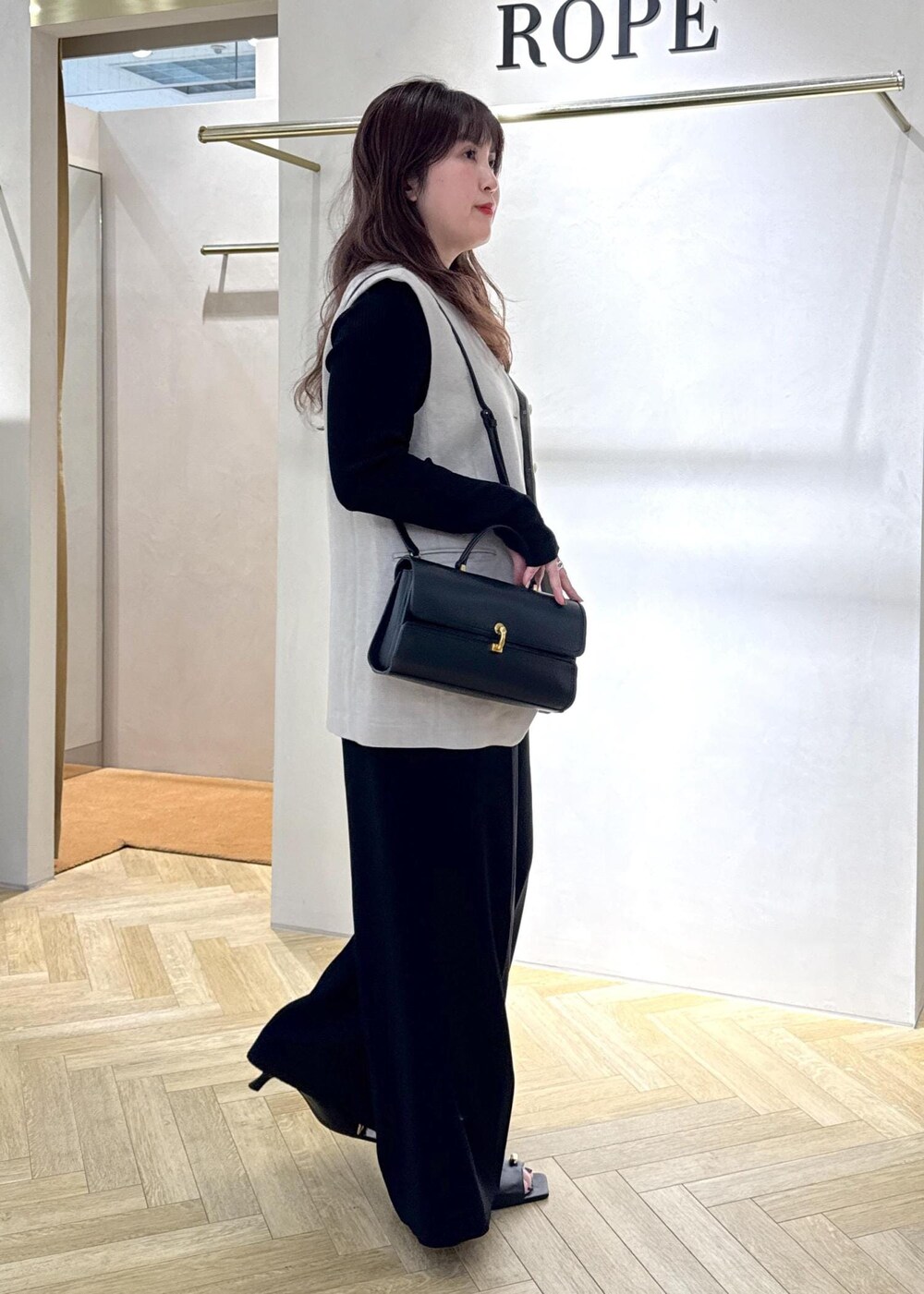 ブラック系のその他パンツ、ブラック系のショルダーバッグ、ブラック系のサンダルを着用したレディースの春コーディネートの2枚目の写真