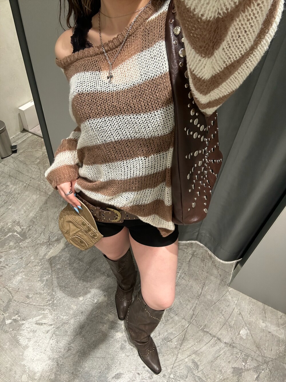 ホワイト系のニット/セーター、グレー系のその他パンツ、ブラック系のブーツを着用したレディースの冬コーディネートの4枚目の写真