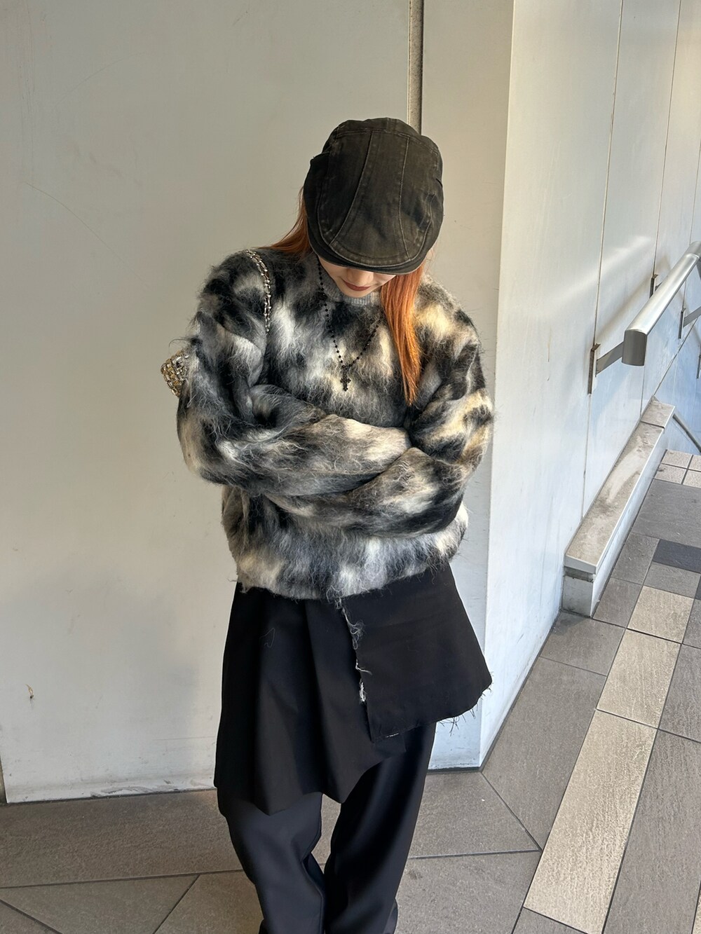 グレー系のニット/セーター、ブラック系のスカート、ブラック系のスラックスを着用したレディースの冬コーディネートの3枚目の写真