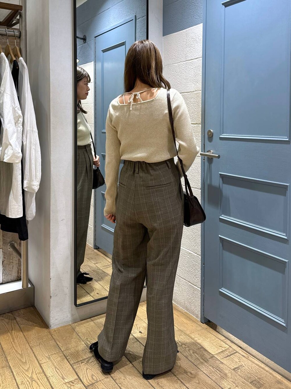 ブラック系のパンプス、ブラウン系のショルダーバッグ、ブラウン系のスラックスを着用したレディースの秋コーディネートの5枚目の写真