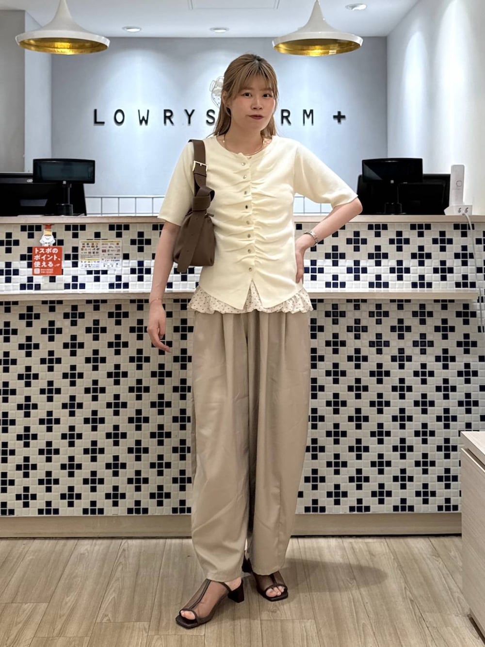 ベージュ系のその他パンツ、ブラウン系のショルダーバッグ、ブラウン系のサンダルを着用したレディースの夏コーディネートの2枚目の写真