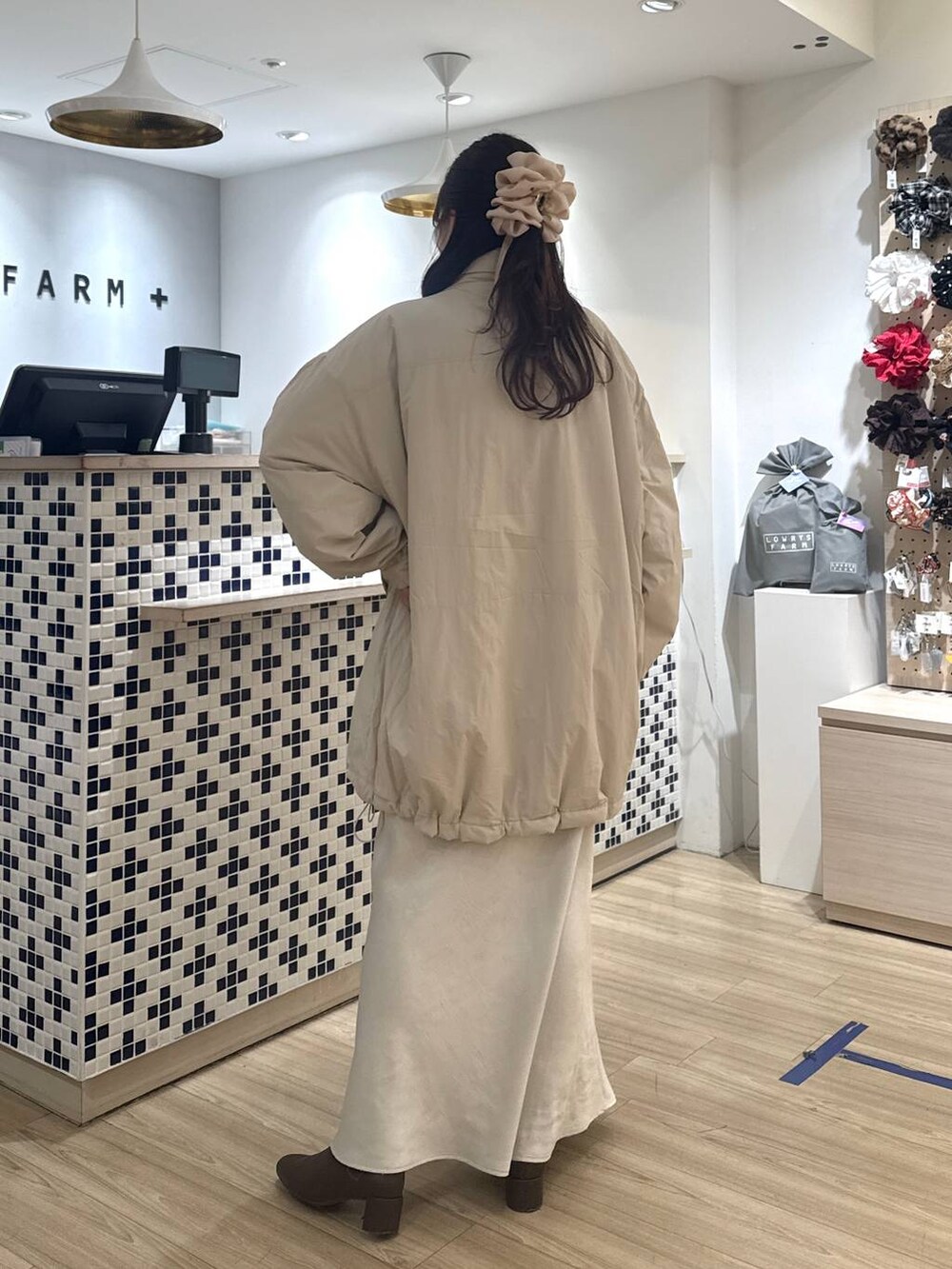 ホワイト系のスカート、ベージュ系のカーディガン/ボレロ、ブラウン系のブーツを着用したレディースの冬コーディネートの4枚目の写真