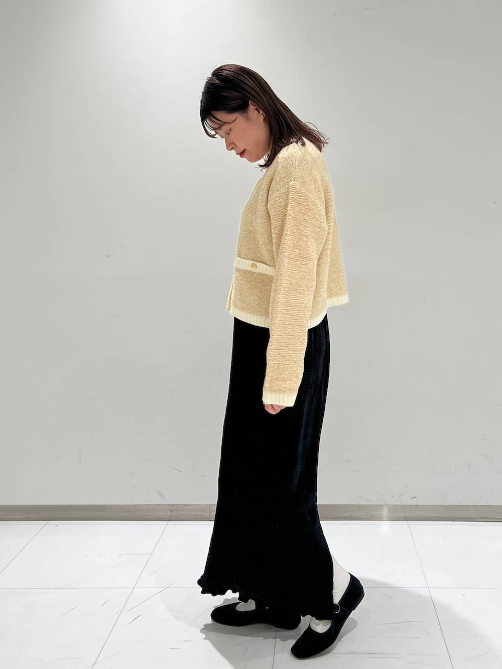 その他のパンプス、ホワイト系のカーディガン/ボレロ、ブラック系のスカートを着用したレディースの秋コーディネートの3枚目の写真