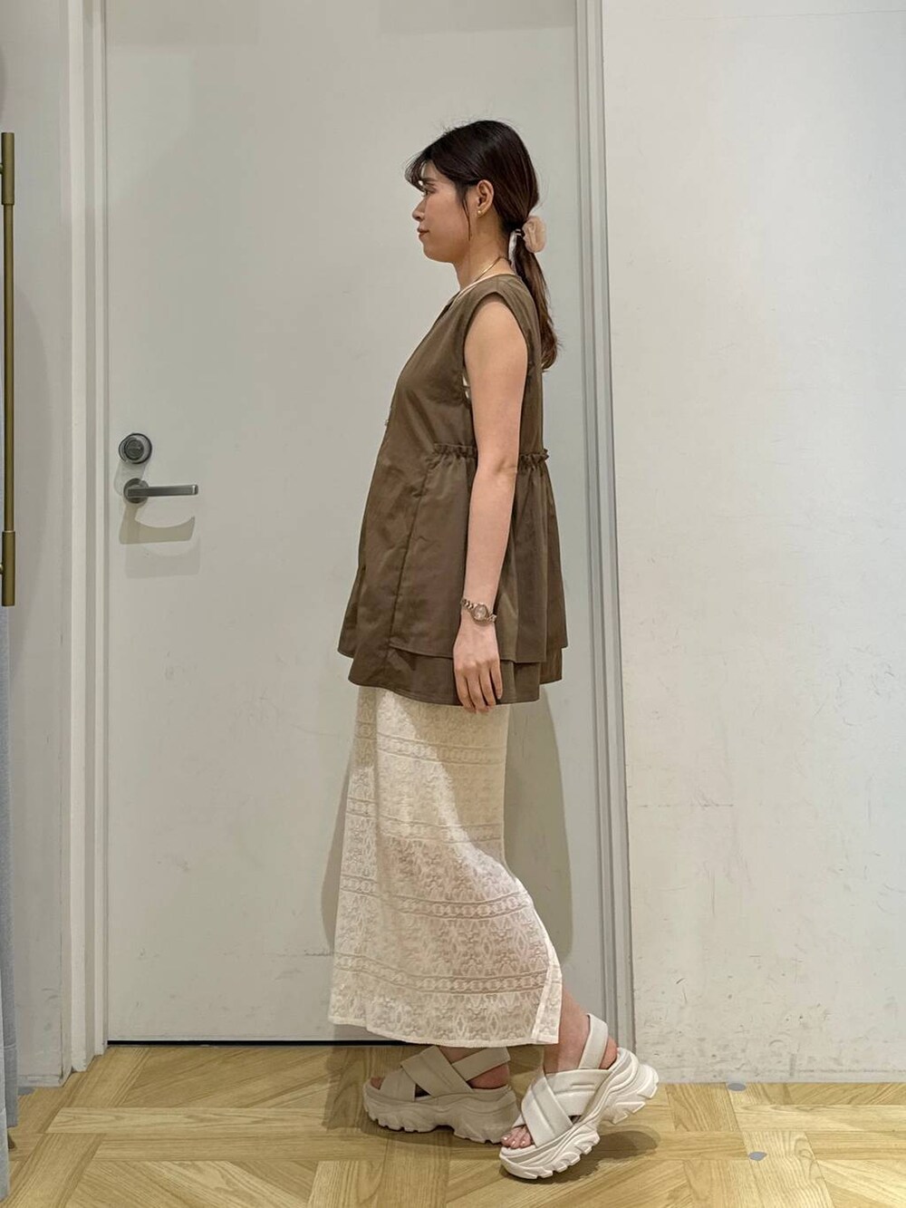 ホワイト系のキャミソール、ホワイト系のサンダル、ホワイト系のスカートを着用したレディースの夏コーディネートの3枚目の写真