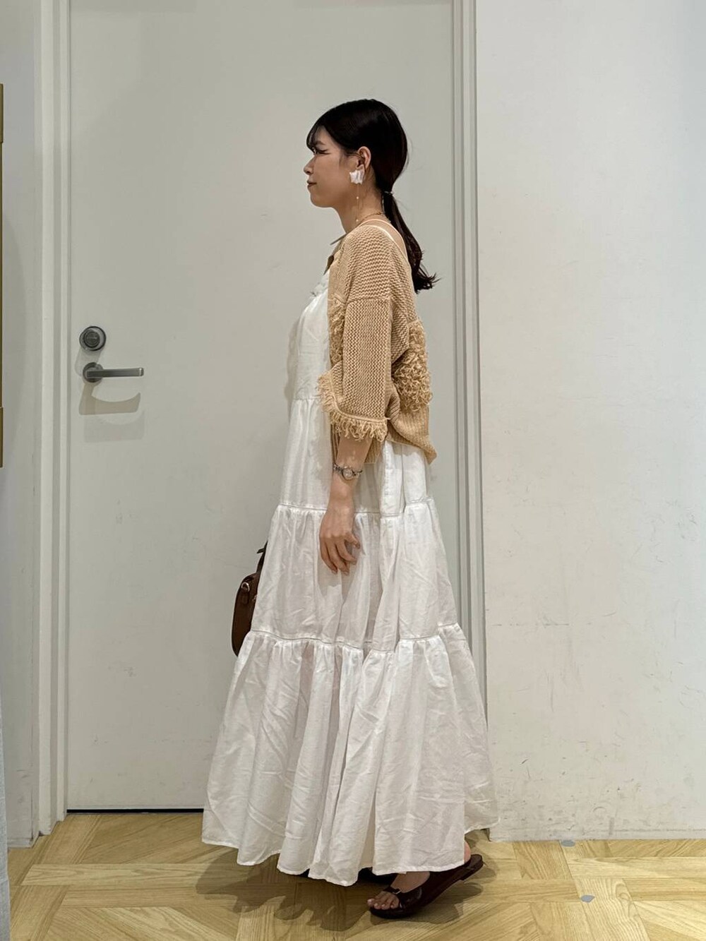 ホワイト系のワンピース、ブラウン系のサンダル、ブラウン系のショルダーバッグを着用したレディースの夏コーディネートの4枚目の写真