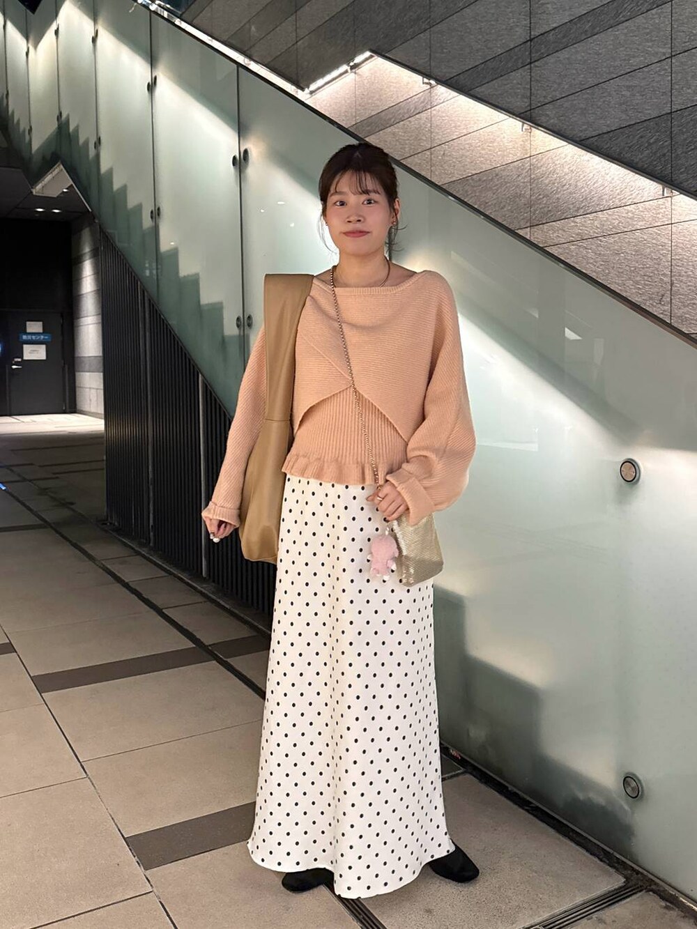 ゴールド系のショルダーバッグ、ホワイト系のスカート、ピンク系のニット/セーターを着用したレディースの秋コーディネートの3枚目の写真