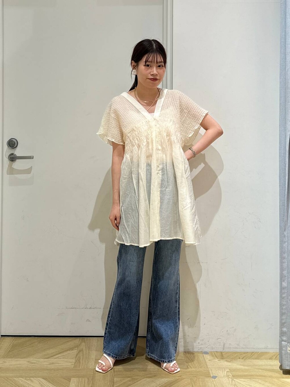 ホワイト系のサンダル、ブルー系のデニムパンツ、ホワイト系のシャツ/ブラウスを着用したレディースの夏コーディネートの2枚目の写真