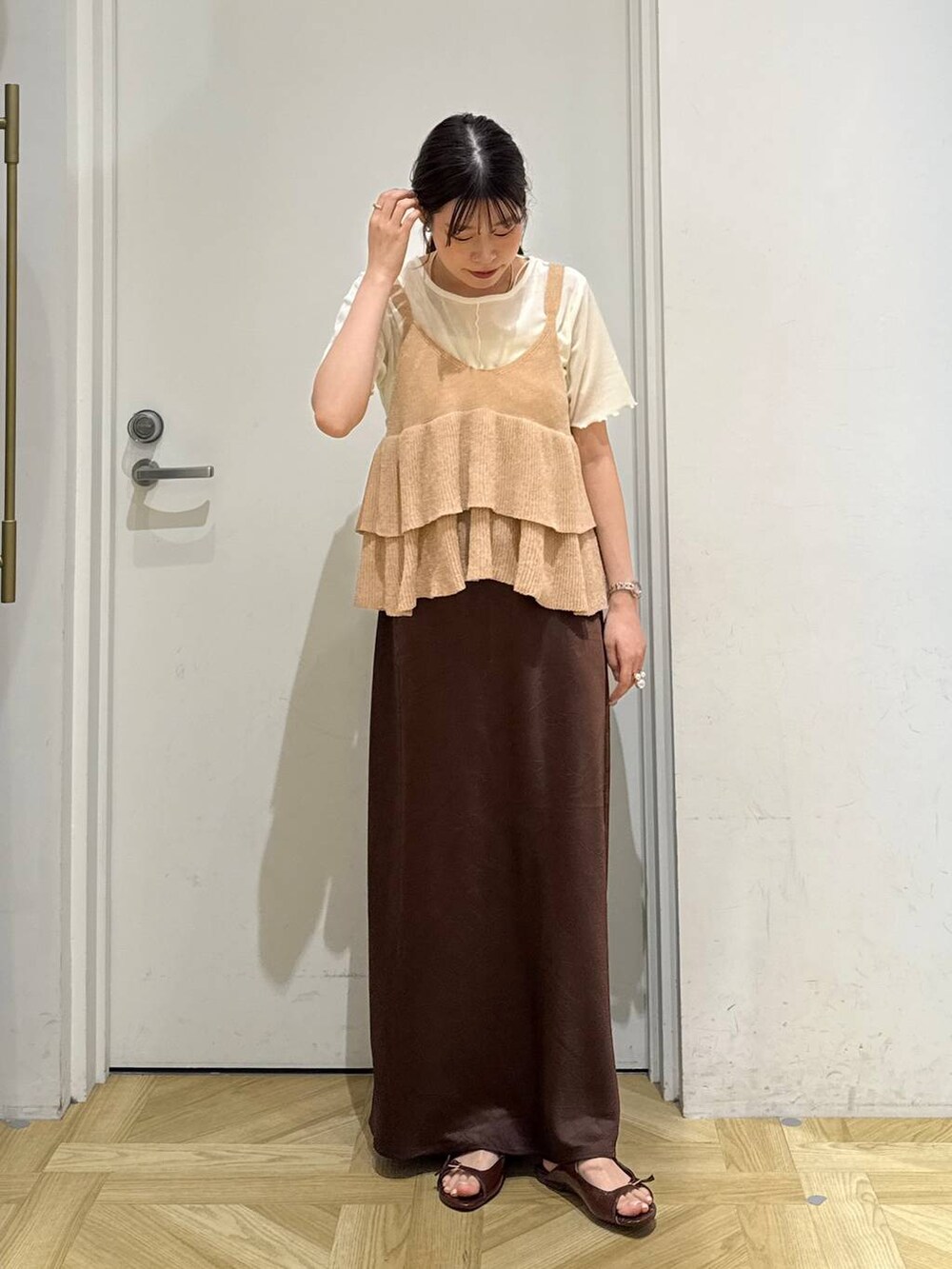 ブラウン系のスカート、ブラウン系のサンダル、ホワイト系のカーディガン/ボレロを着用したレディースの秋コーディネートの2枚目の写真