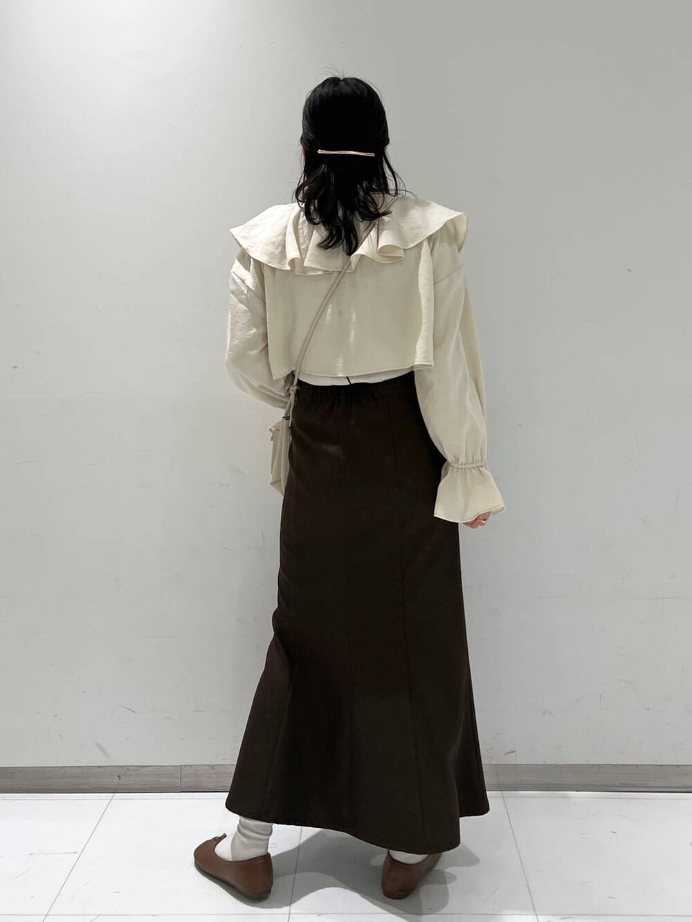 ホワイト系のショルダーバッグ、その他のTシャツ/カットソー、ブラウン系のスカートを着用したレディースの冬コーディネートの4枚目の写真