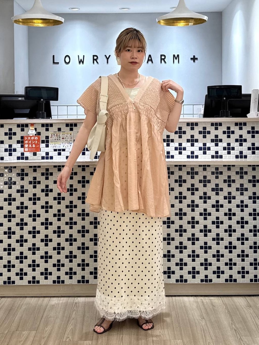 ブラウン系のシャツ/ブラウス、ホワイト系のショルダーバッグ、ブラウン系のサンダルを着用したレディースの春コーディネートの3枚目の写真
