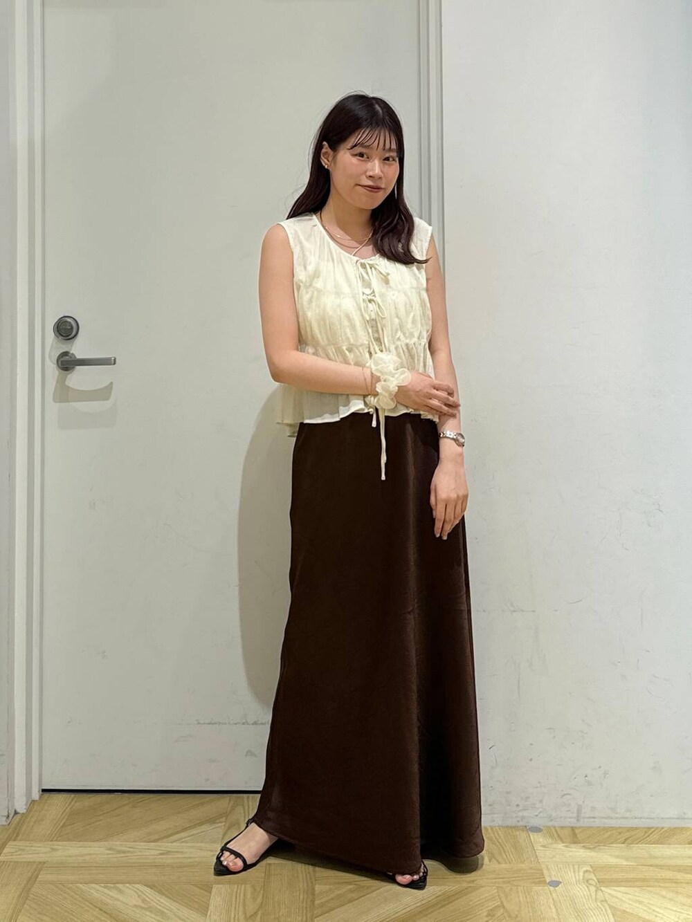 ブラック系のサンダル、ブラウン系のスカート、ホワイト系のシャツ/ブラウスを着用したレディースの夏コーディネートの2枚目の写真