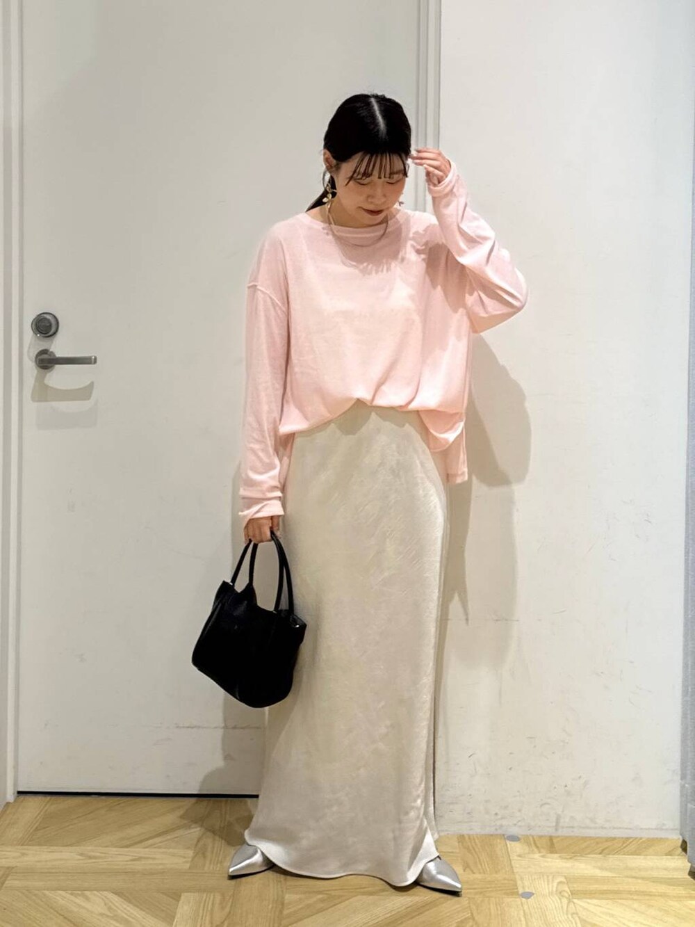 ホワイト系のスカート、ブラック系のショルダーバッグ、シルバー系のパンプスを着用したレディースの夏コーディネートの2枚目の写真