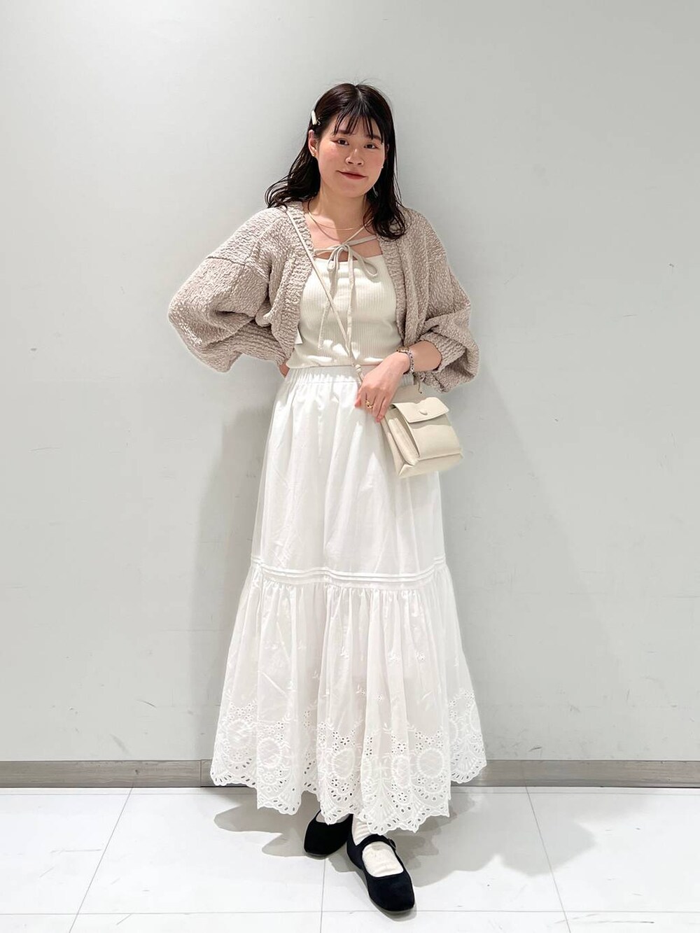 ホワイト系のスカート、ホワイト系のショルダーバッグ、その他のパンプスを着用したレディースの冬コーディネートの3枚目の写真