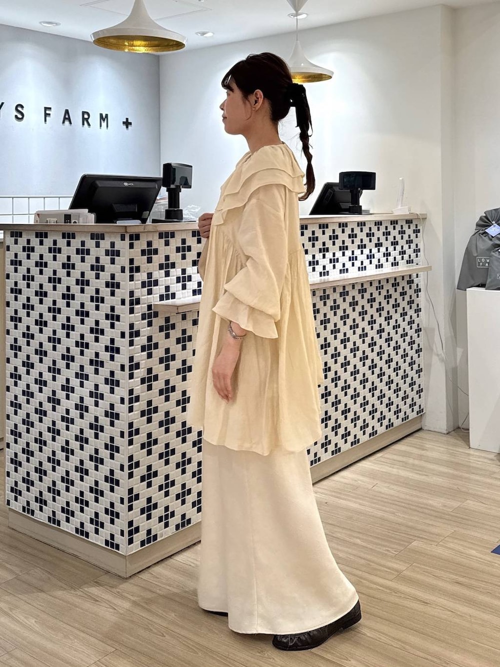 ホワイト系のスカート、ベージュ系のショルダーバッグ、ブラウン系のローファーを着用したレディースの春コーディネートの3枚目の写真