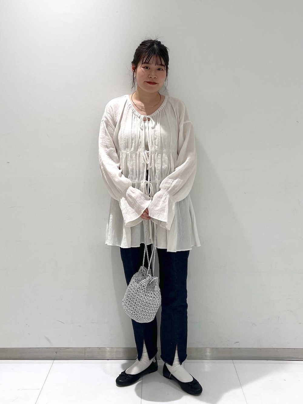 ホワイト系のシャツ/ブラウス、ブラック系のバレエシューズ、ブルー系のデニムパンツを着用したレディースの春コーディネートの2枚目の写真