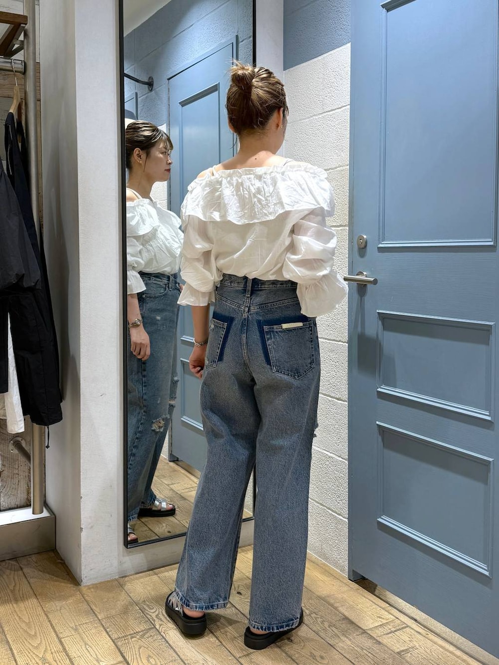 シルバー系のスニーカー、ホワイト系のシャツ/ブラウス、ブルー系のデニムパンツを着用したレディースの夏コーディネートの3枚目の写真