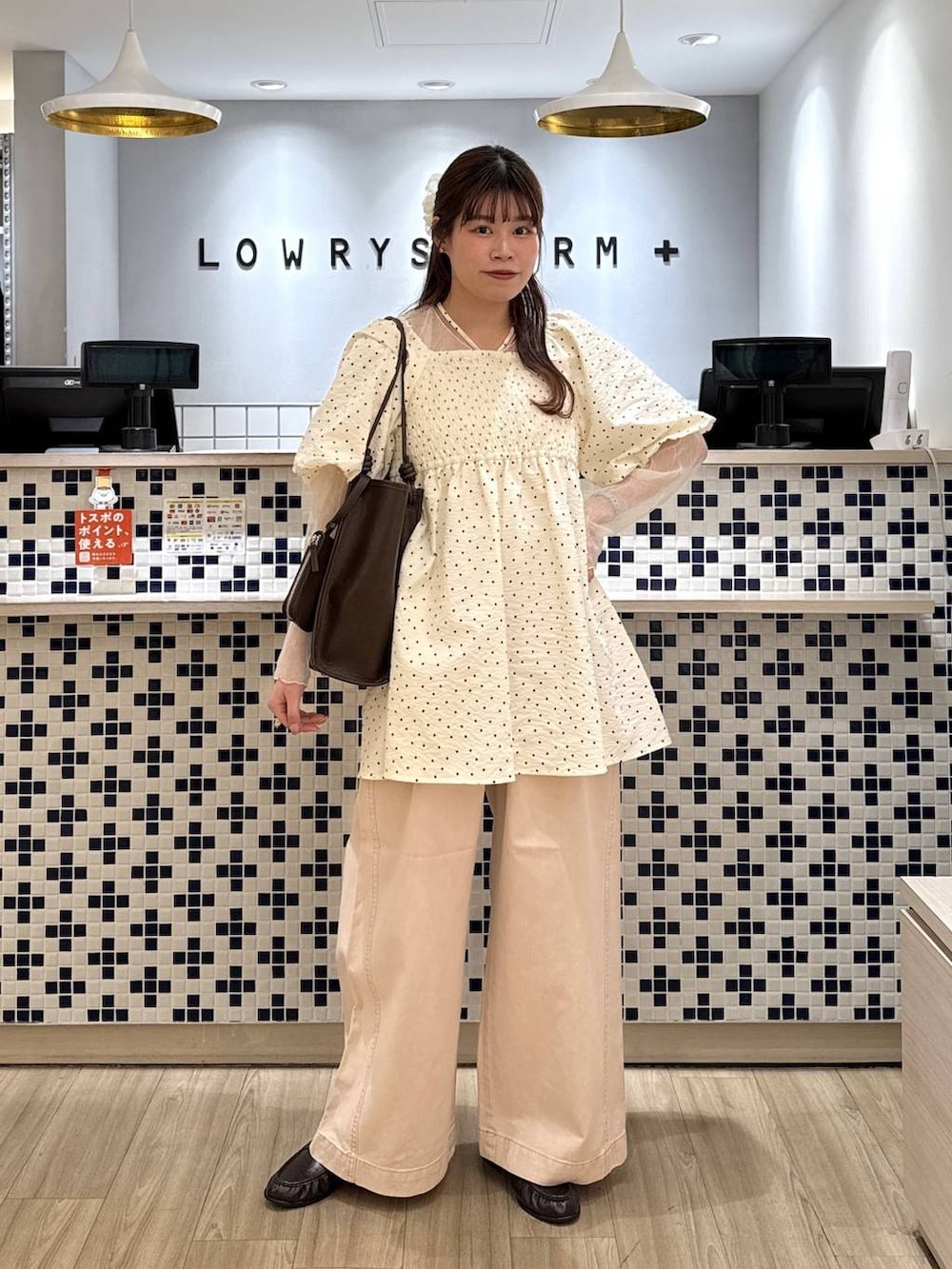 ピンク系のデニムパンツ、ブラウン系のローファー、ブラウン系のトートバッグを着用したレディースの春コーディネートの2枚目の写真