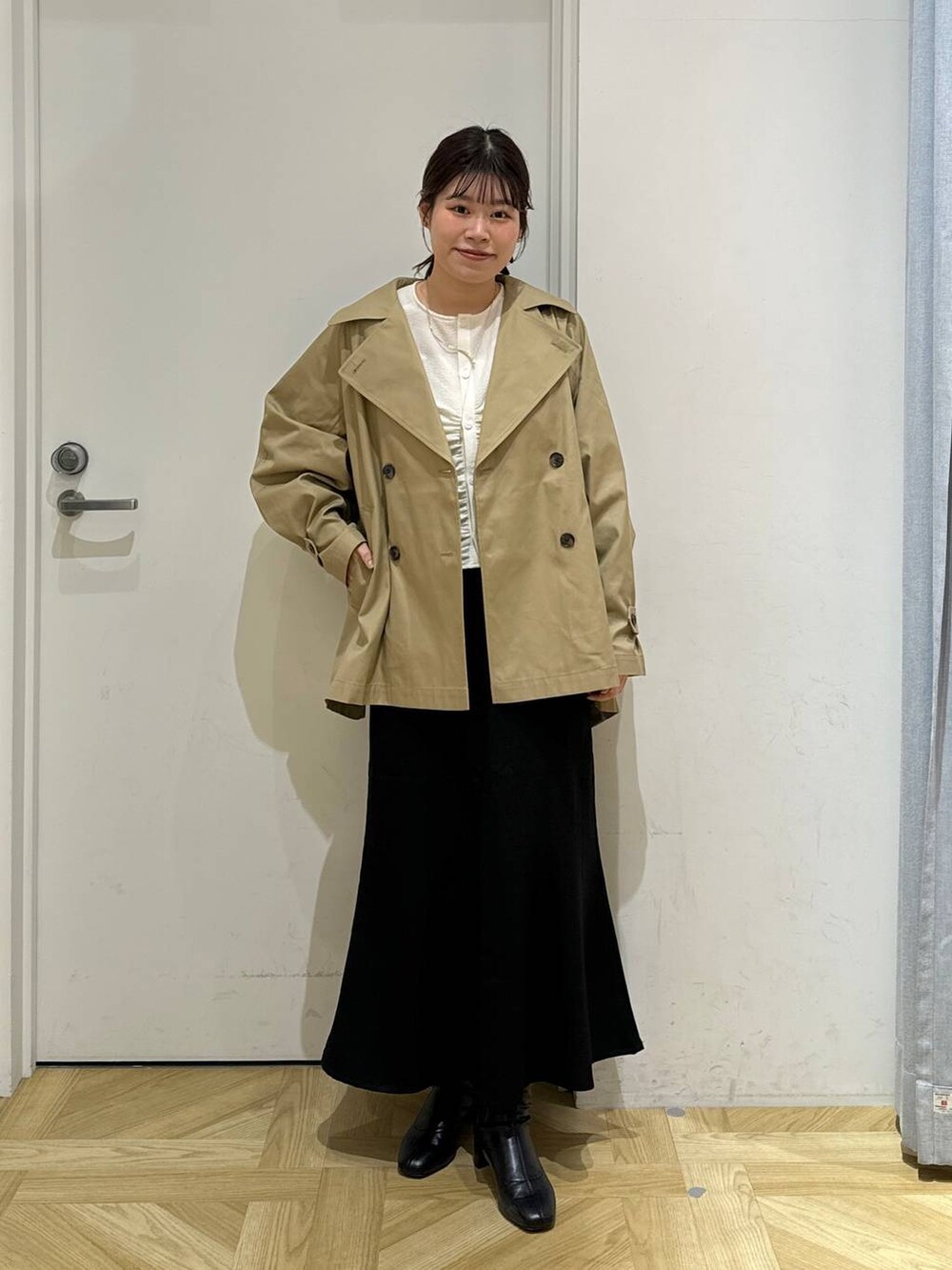 ブラック系のブーツ、ホワイト系のシャツ/ブラウス、ブラウン系のトレンチコートを着用したレディースの春コーディネートの3枚目の写真