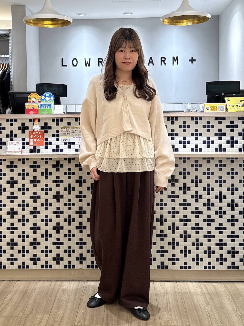 ホワイト系のカーディガン/ボレロ、ホワイト系のTシャツ/カットソー、ブラウン系のスウェットパンツを着用したレディースの秋コーディネートの3枚目の写真