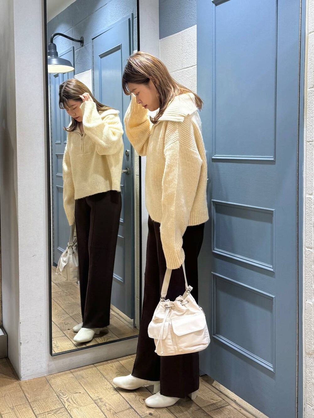 ホワイト系のショルダーバッグ、ホワイト系のブーツ、ホワイト系のニット/セーターを着用したレディースの秋コーディネートの3枚目の写真