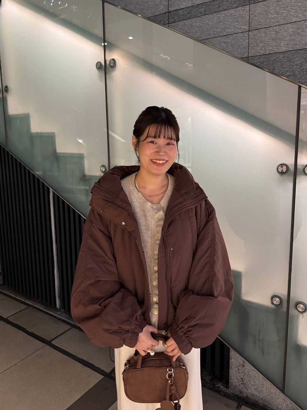 ブラウン系のその他アウター、ホワイト系のスカート、ブラウン系のボストンバッグを着用したレディースの秋コーディネートの6枚目の写真