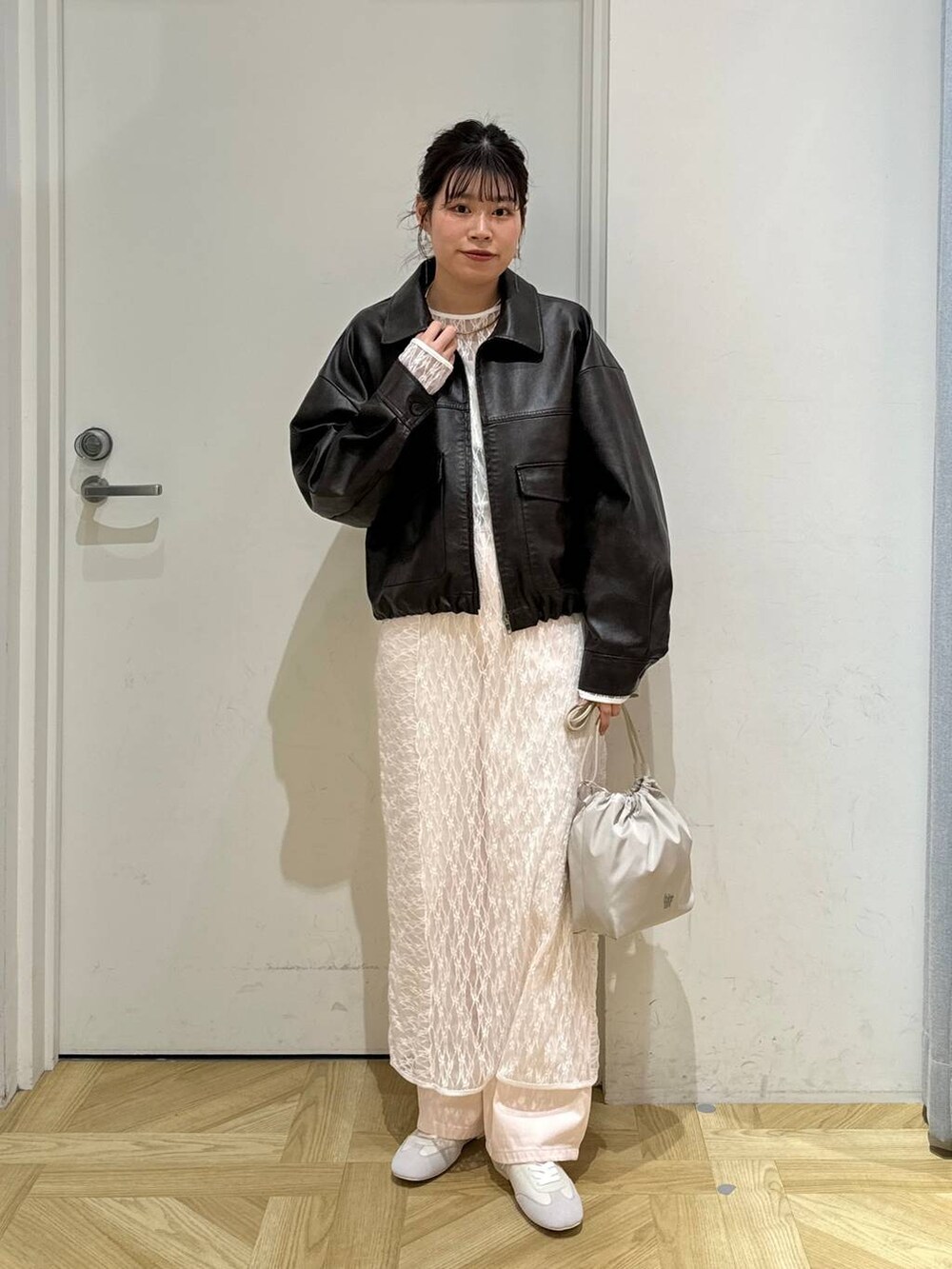 ピンク系のデニムパンツ、ホワイト系のショルダーバッグ、ホワイト系のスニーカーを着用したレディースの春コーディネートの2枚目の写真