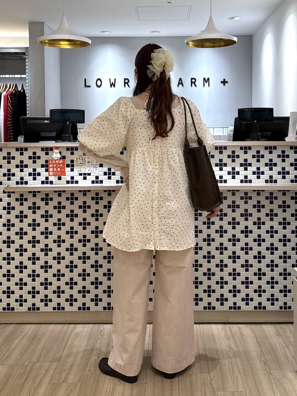 ピンク系のデニムパンツ、ブラウン系のローファー、ブラウン系のトートバッグを着用したレディースの春コーディネートの3枚目の写真