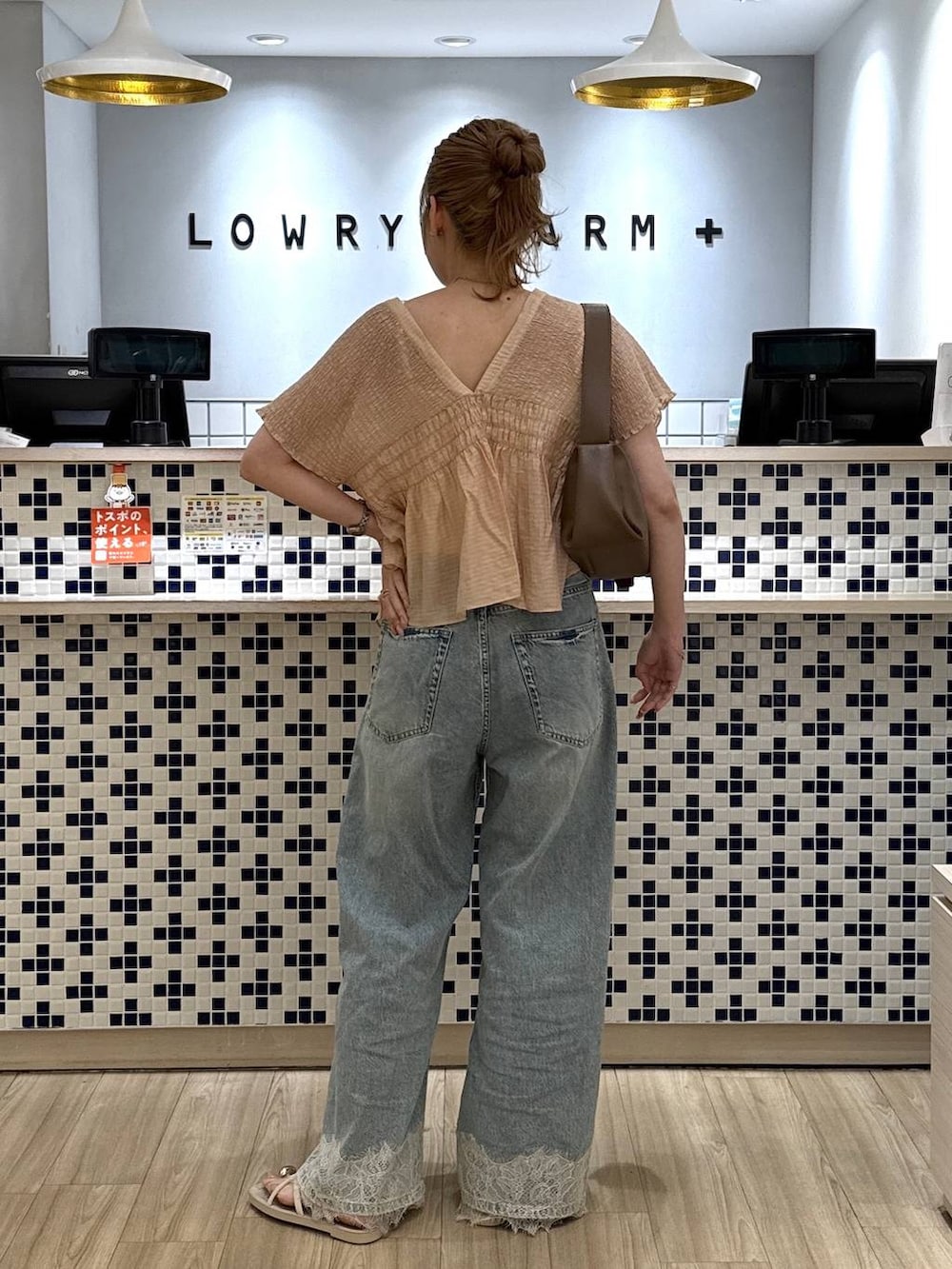 ブルー系のデニムパンツ、ホワイト系のサンダル、ホワイト系のショルダーバッグを着用したレディースの夏コーディネートの4枚目の写真
