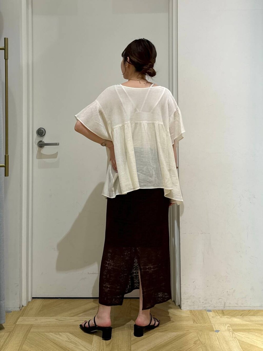 ブラック系のサンダル、ブラウン系のスカート、ホワイト系のシャツ/ブラウスを着用したレディースの夏コーディネートの4枚目の写真