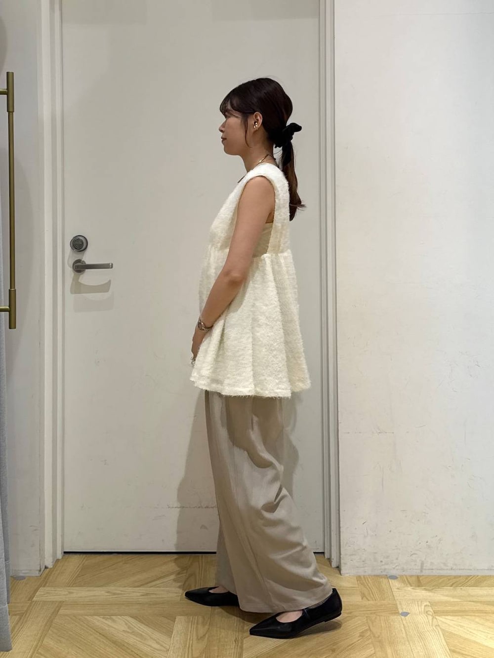 ベージュ系のその他パンツ、ブラック系のパンプス、ホワイト系のベストを着用したレディースの秋コーディネートの5枚目の写真