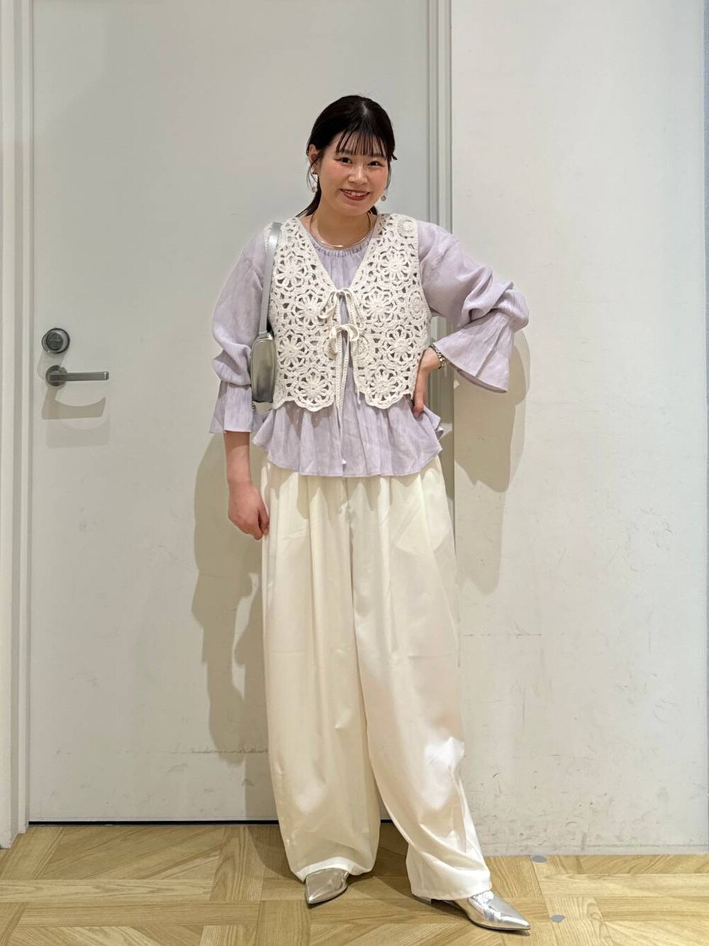 シルバー系のトートバッグ、シルバー系のパンプス、パープル系のシャツ/ブラウスを着用したレディースの春コーディネートの2枚目の写真