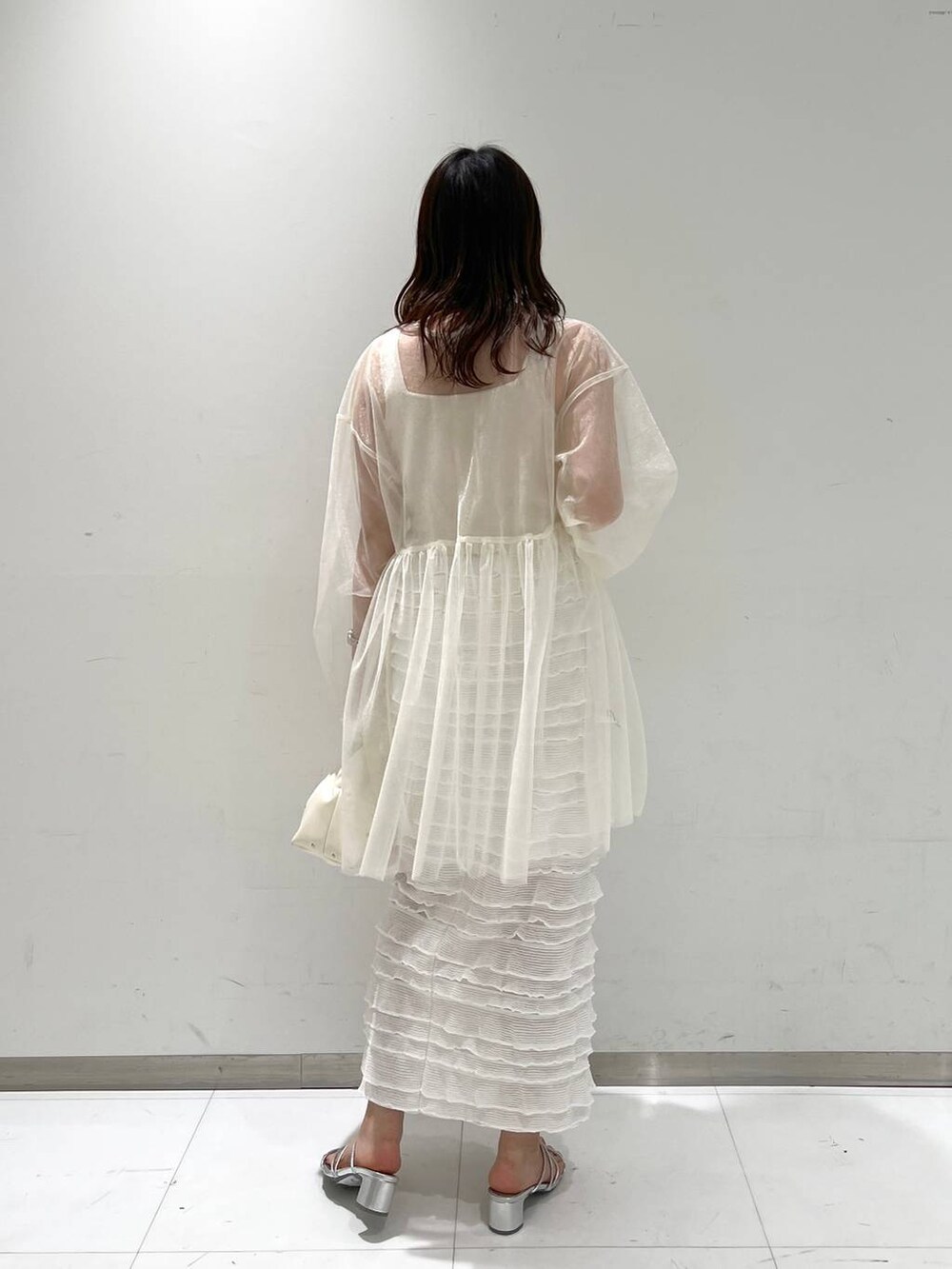 ホワイト系のタンクトップ、ホワイト系のスカート、ベージュ系のハンドバッグを着用したレディースの春コーディネートの4枚目の写真