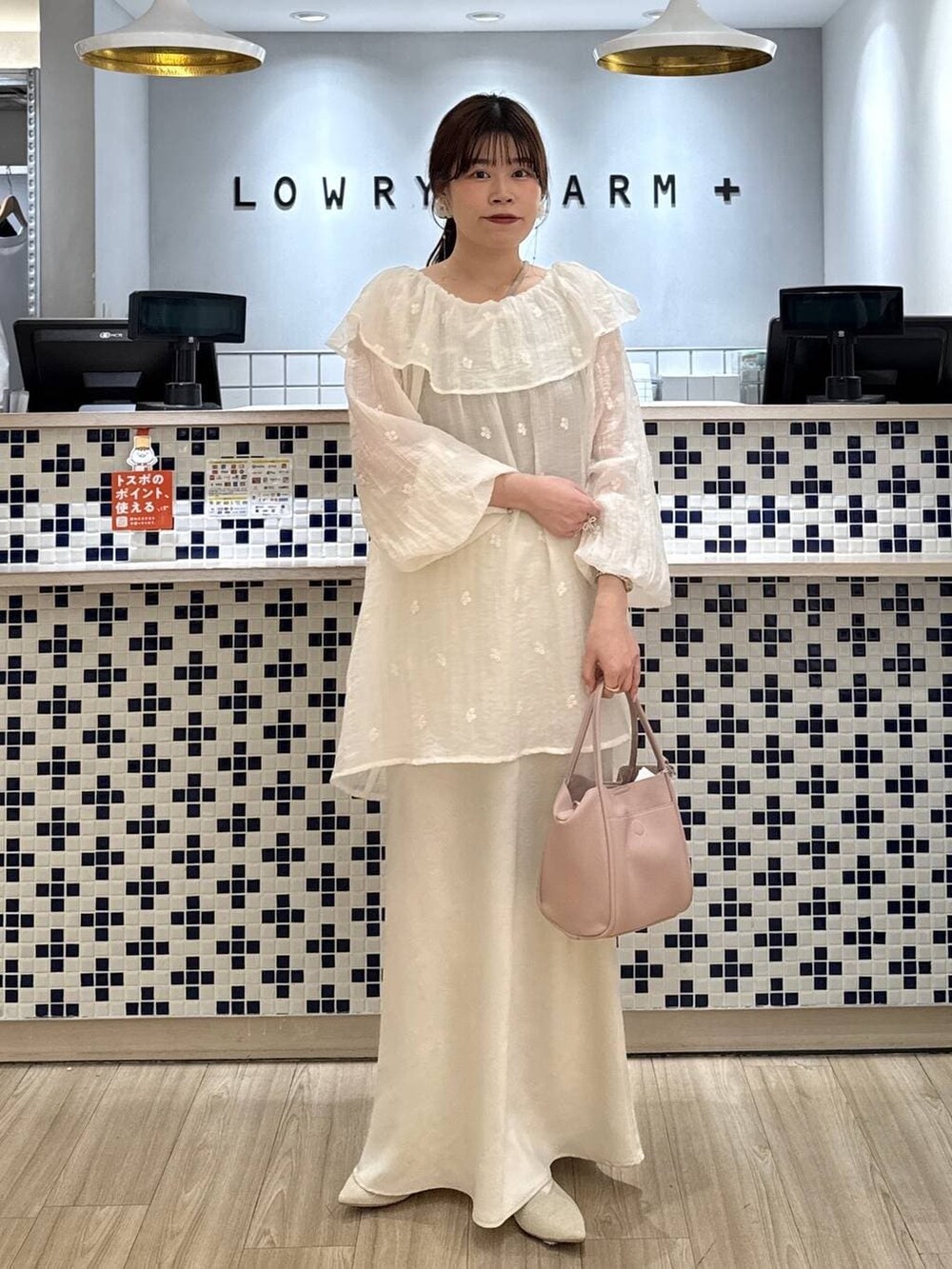 ホワイト系のスカート、ピンク系のショルダーバッグ、ホワイト系のパンプスを着用したレディースの春コーディネートの2枚目の写真