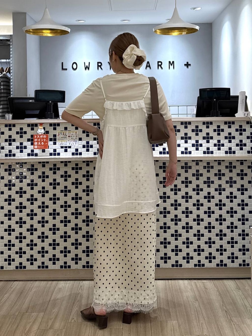 ホワイト系のTシャツ/カットソー、ブラウン系のショルダーバッグ、ブラウン系のサンダルを着用したレディースの春コーディネートの4枚目の写真