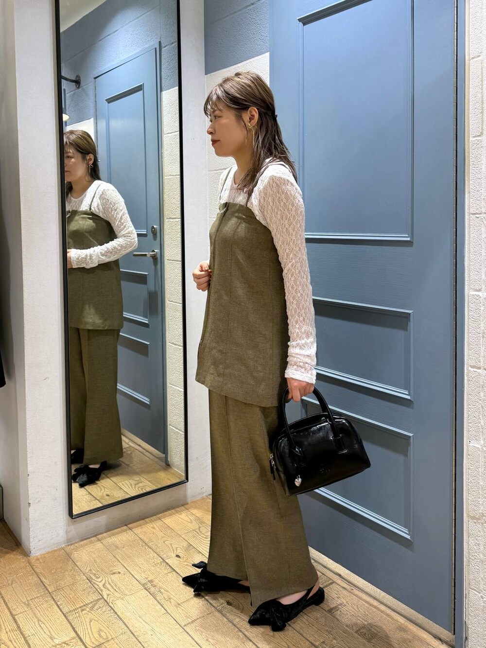 ブラック系のパンプス、ホワイト系のTシャツ/カットソー、ブラウン系のスラックスを着用したレディースの秋コーディネートの4枚目の写真