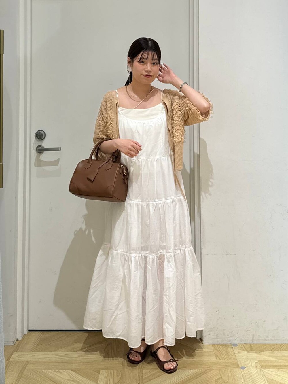 ホワイト系のワンピース、ブラウン系のサンダル、ブラウン系のショルダーバッグを着用したレディースの夏コーディネートの2枚目の写真