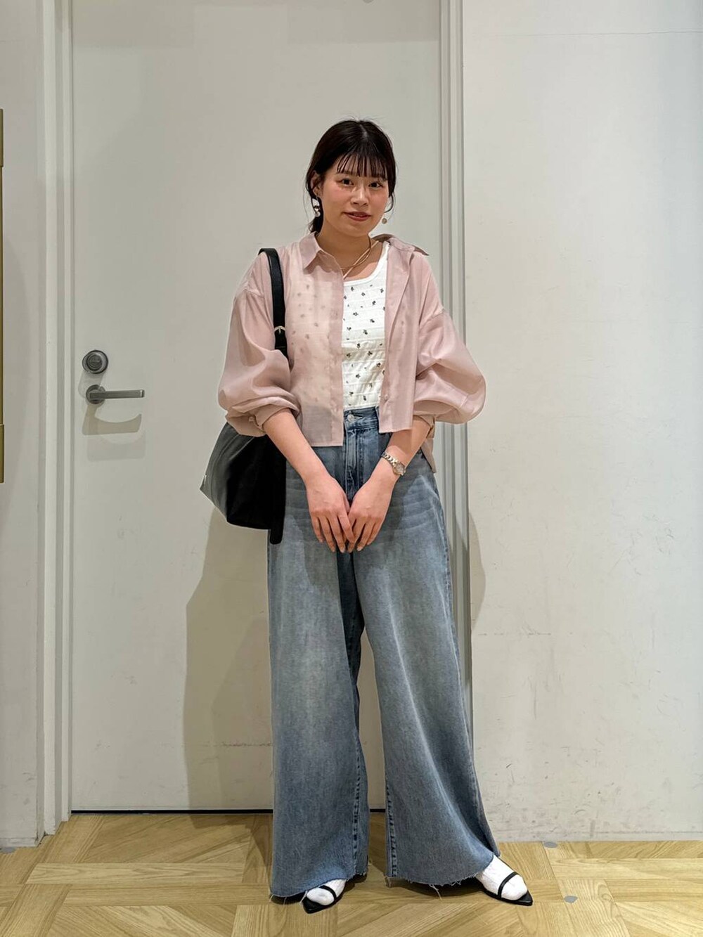 ピンク系のシャツ/ブラウス、ブラック系のサンダル、ブラック系のショルダーバッグを着用したレディースの春コーディネートの2枚目の写真