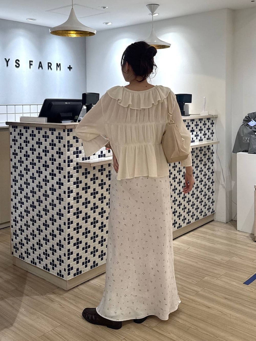 ホワイト系のスカート、ベージュ系のショルダーバッグ、ブラウン系のローファーを着用したレディースの春コーディネートの5枚目の写真