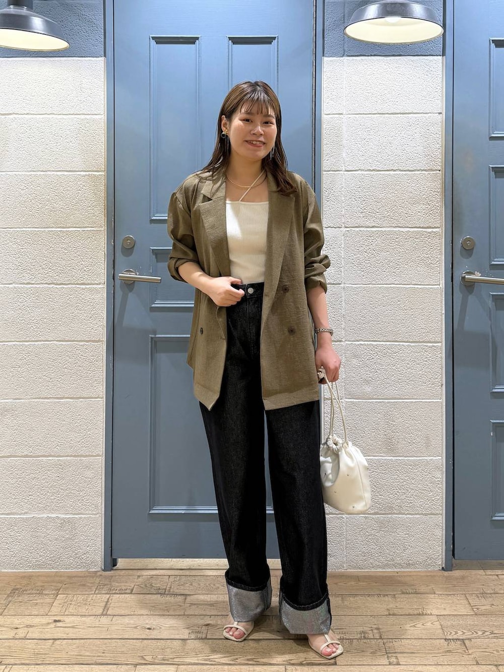 ホワイト系のショルダーバッグ、グレー系のデニムパンツ、ホワイト系のタンクトップを着用したレディースの夏コーディネートの2枚目の写真