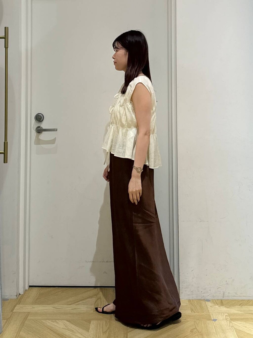 ブラック系のサンダル、ブラウン系のスカート、ホワイト系のシャツ/ブラウスを着用したレディースの夏コーディネートの3枚目の写真