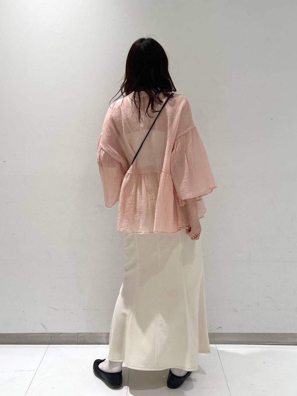 ブラック系のショルダーバッグ、ブラック系のバレエシューズ、ホワイト系のスカートを着用したレディースの春コーディネートの5枚目の写真