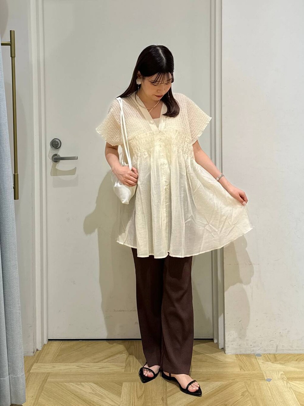 ブラック系のサンダル、ブラウン系のその他パンツ、ホワイト系のシャツ/ブラウスを着用したレディースの夏コーディネートの2枚目の写真