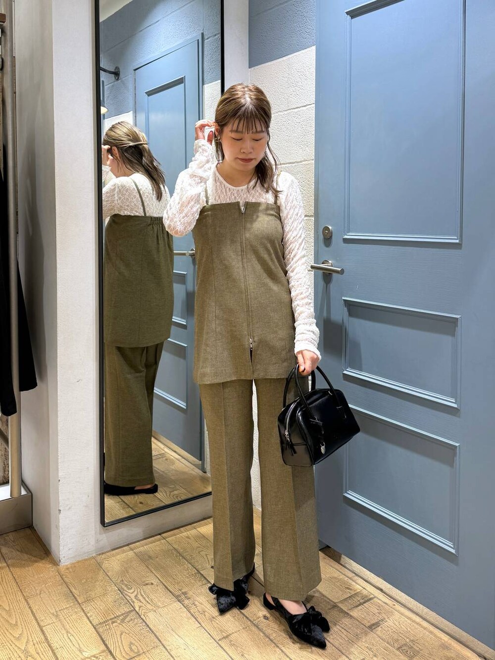 ブラック系のパンプス、ホワイト系のTシャツ/カットソー、ブラウン系のスラックスを着用したレディースの秋コーディネートの2枚目の写真