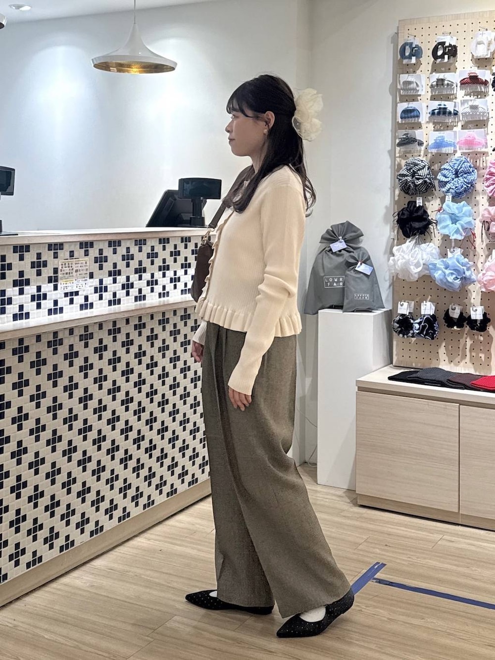 ブラック系のパンプス、ベージュ系のショルダーバッグ、ホワイト系のTシャツ/カットソーを着用したレディースの春コーディネートの3枚目の写真