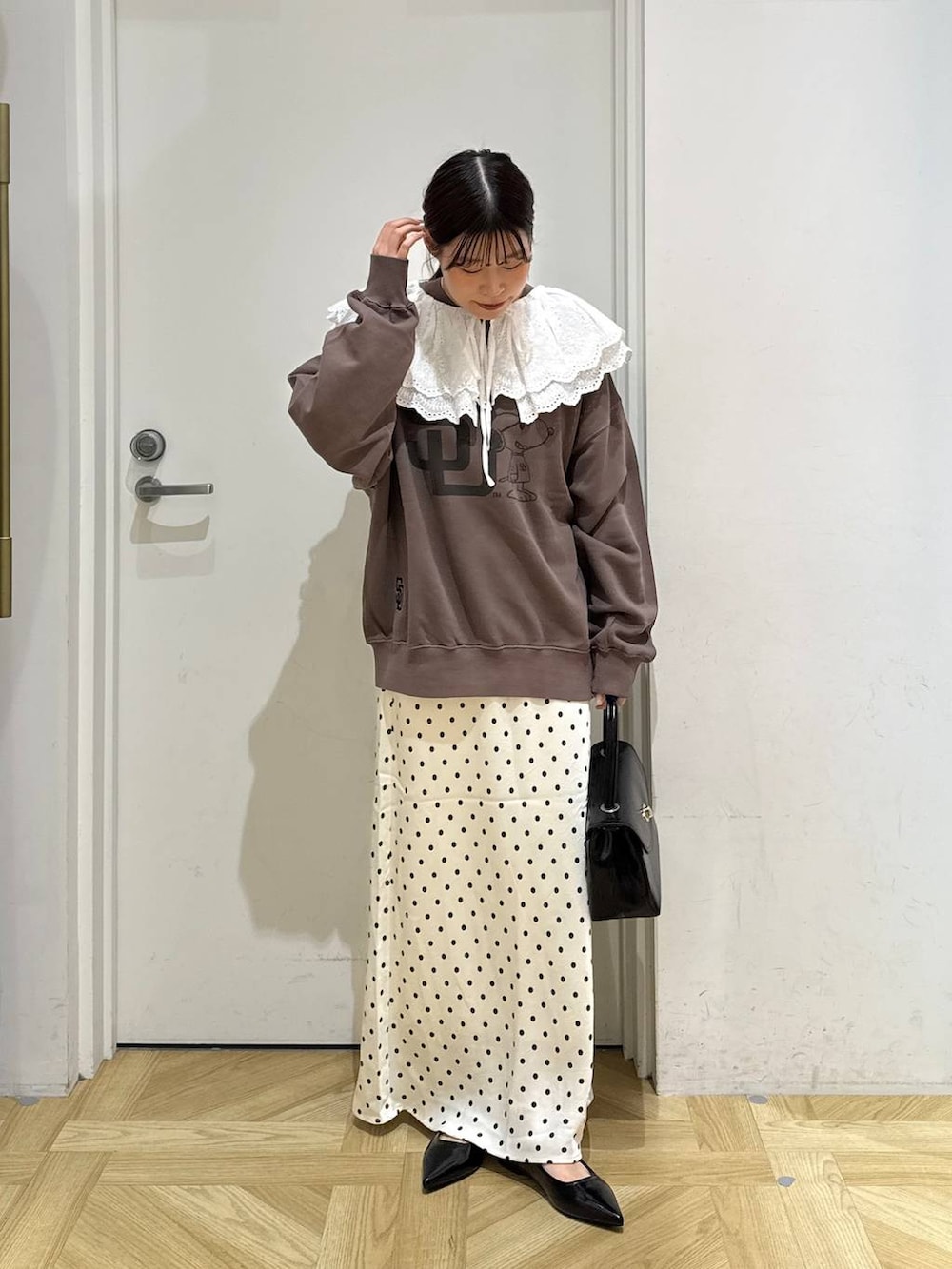 ホワイト系のスカート、ブラック系のボストンバッグ、ブラック系のパンプスを着用したレディースの秋コーディネートの4枚目の写真