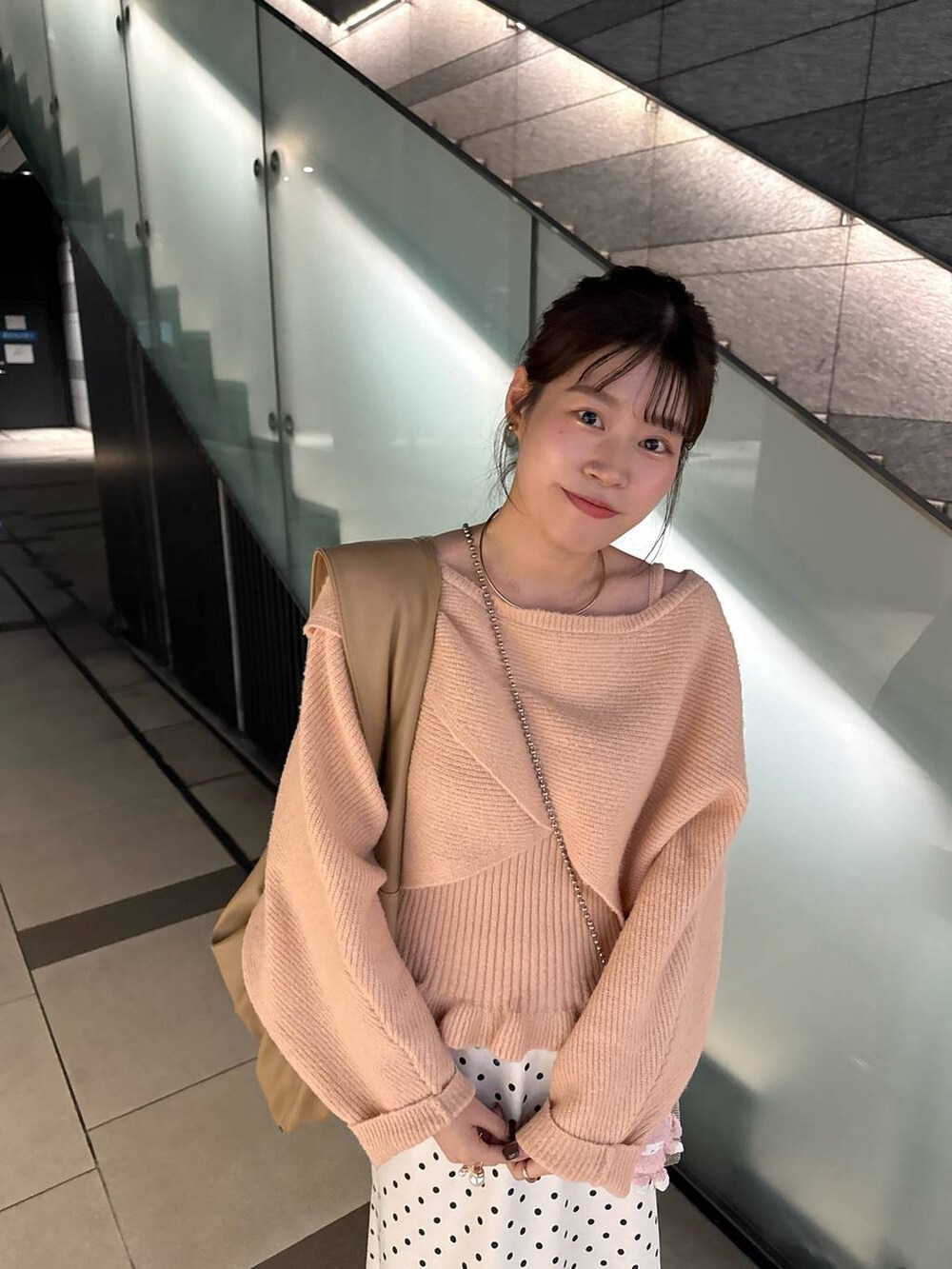 ゴールド系のショルダーバッグ、ホワイト系のスカート、ピンク系のニット/セーターを着用したレディースの秋コーディネートの2枚目の写真