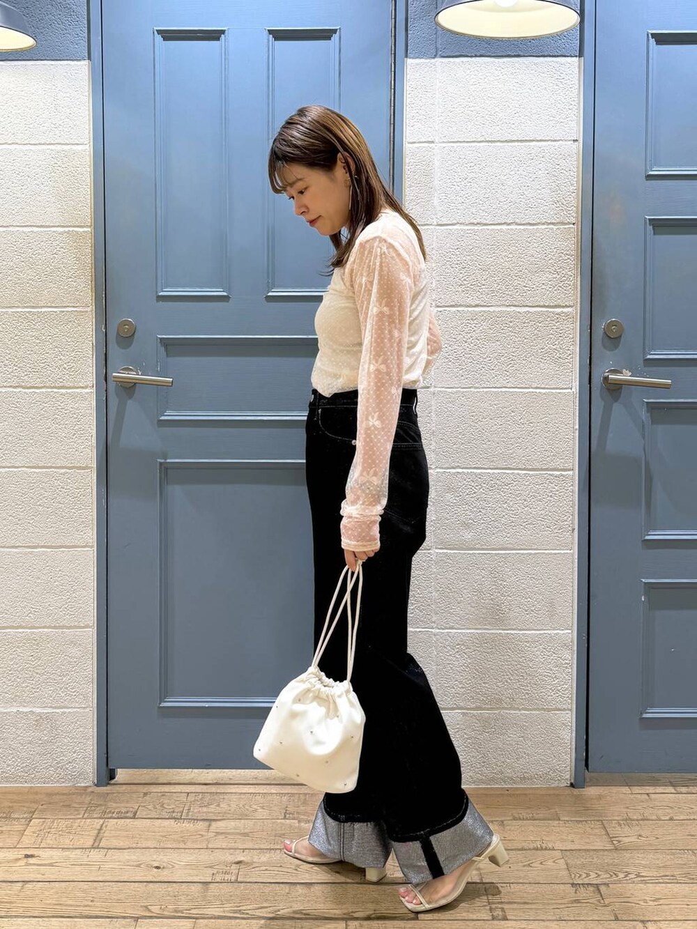 ホワイト系のショルダーバッグ、グレー系のデニムパンツ、ホワイト系のタンクトップを着用したレディースの夏コーディネートの2枚目の写真